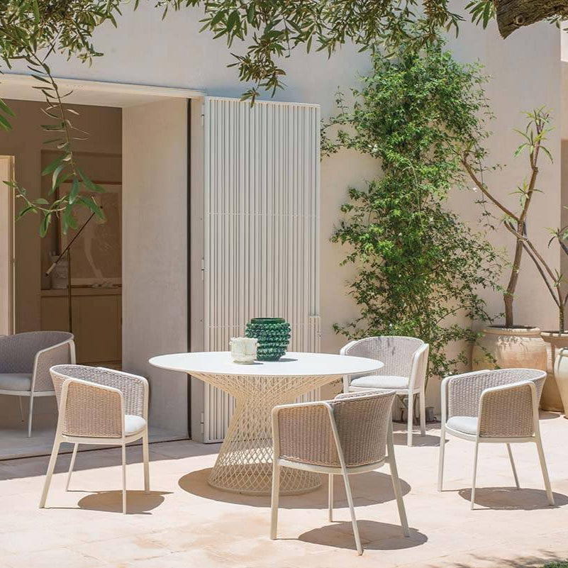 Outdoor lounge setting with Minimal Flat Rope Garden Armchairs in white, placed around a round dining table in a Mediterranean patio | EMU Carousel