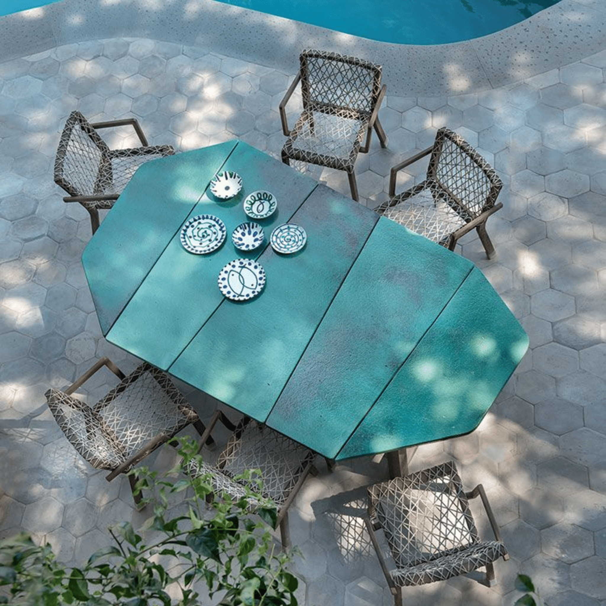 Turquoise Asymmetrical Stone Coffee Table by Ethimo | High-End Outdoor Furniture for Luxury Outdoor Living | Shown by a poolside with matching woven chairs.