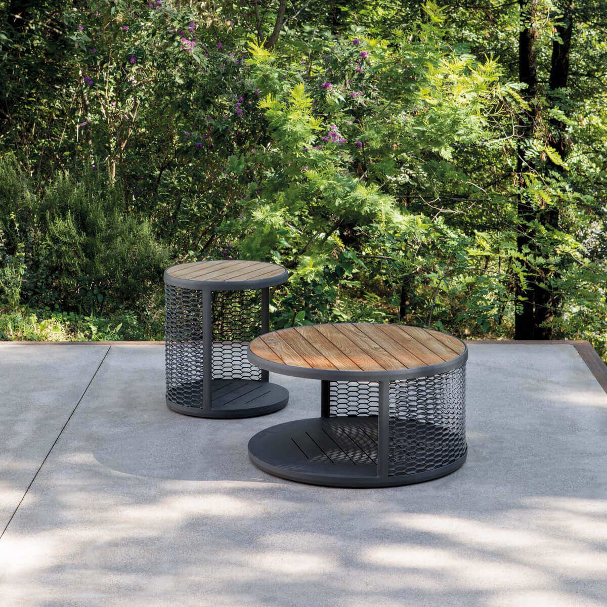 Contemporary round coffee tables with mesh design in a lush outdoor setting | Luxury garden coffee tables | Durable outdoor furniture | Atmosphera Switch