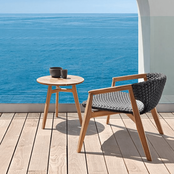 Circular Outdoor Teak Coffee Table and Matching Chair by the Ocean | High-End Outdoor Furniture | Luxury Teak Table and Seating.