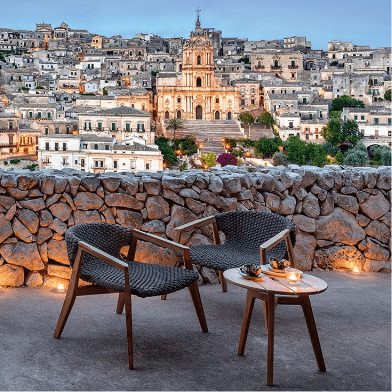 Circular Outdoor Teak Coffee Table and Chairs in a Scenic Evening Setting | Luxury Outdoor Furniture | High-End Garden Decor.